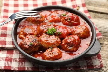 Delicious meatballs with tomato sauce in baking dish on table, closeup