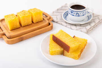 Bika ambon or kuih bingka, a traditional Indonesian snack, which has a nesting and soft texture, with a golden color. Served already cut.