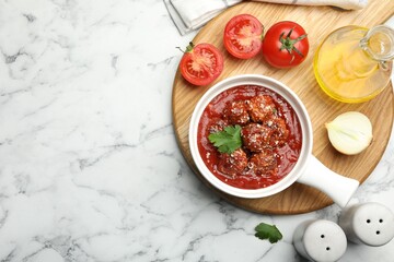 Delicious meatballs with tomato sauce, parmesan cheese and parsley served on white marble table, flat lay. Space for text