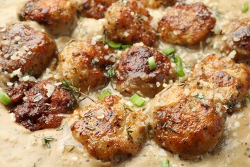 Delicious meatballs with gravy cream sauce and herbs, closeup