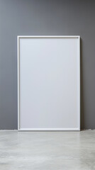 White, blank picture frame mockup on the floor against a gray wall