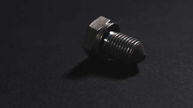 metal bolt on dark background. Chromed screw bolt. Steel bolt. Nuts and bolts. Tools for work.