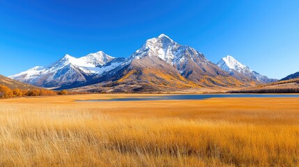 Fototapeta premium Autumnal mountain lake, golden grasses, snow-capped peaks, clear sky, scenic wallpaper
