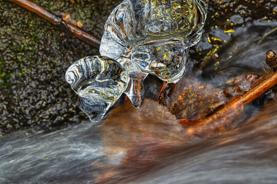 whitewater stream in winter, long exposure, water mist forms ice sculptures on the bank with phascinating light effects