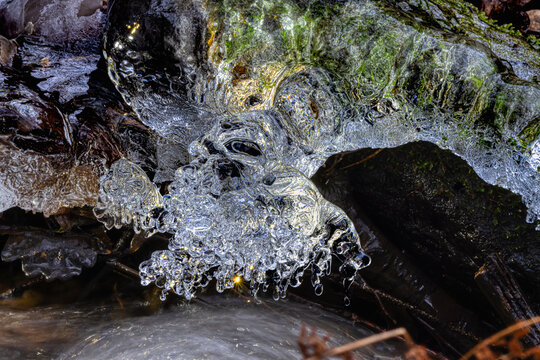 whitewater stream in winter, long exposure, water mist forms ice sculptures on the bank with phascinating light effects