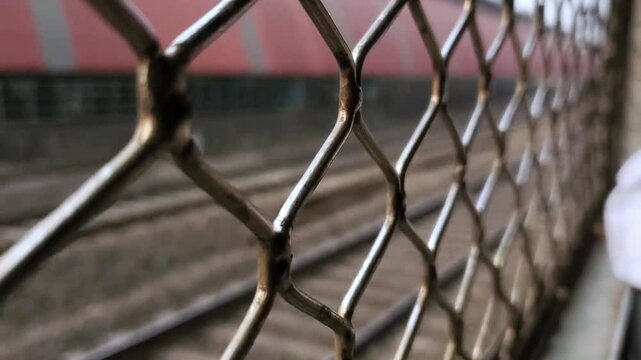 Mumbai, Maharashtra, India - May 1st 2023: Closeup of Indian local metal grill window train speeding passing railway station platform