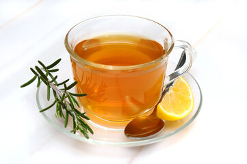 Glass of Tea with a Slice of Lemon, Rosemary and a Teaspoone on a Cup Tray