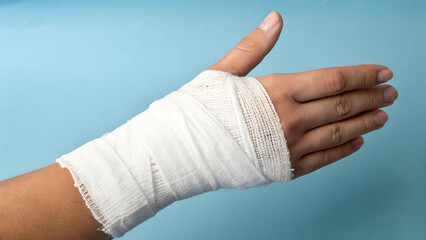 Bandaged hand showing recovery against a soothing blue background