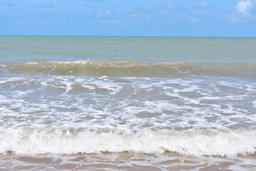 Wave rolling in on a sandy tropical beach