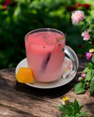 A typical Indonesian herbal drink called wedang uwuh is served on a wooden table with a garden background.