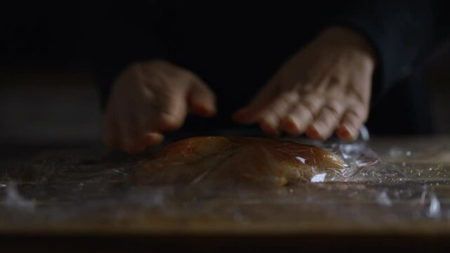 Tenderizing chicken fillet with a rolling pin.