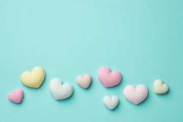 Colorful tiny hearts on pastel blue background. Minimal concept idea. Place for inscription. 