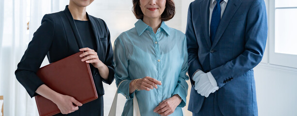 カメラ目線のスーツを着た男女とシニアの女性 © ponta1414