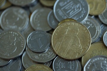 Metal coins of Ukraine of different denominations are scattered. Money texture, business background.
