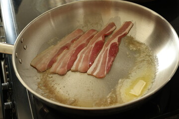 raw bacon and butter melting in a pan