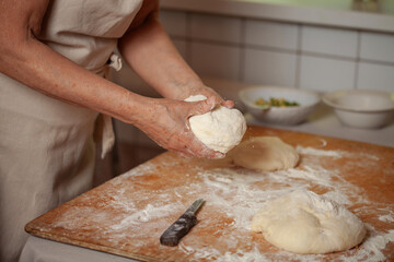 Women's hands make pasty dough