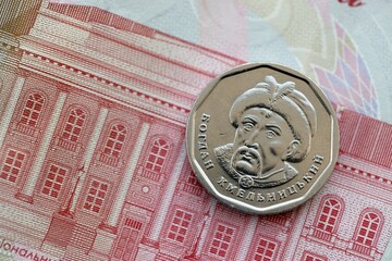 Ukrainian silver coin lies on one hundred hryvnia bill. Financial and business concept. Modern...