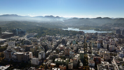 Aerial view of Tirana’s city center on a sunny day, showcasing Skanderbeg Square, modern high-rises, and historic landmarks, with Dajti Mountain in the background. Photo taken 16,11,2024, Tirana, Alba