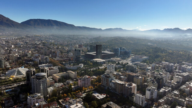 Aerial view of Tirana&rsquo;s city center on a sunny day, showcasing Skanderbeg Square, modern high-rises, and historic landmarks, with Dajti Mountain in the background. Photo taken 16,11,2024, Tirana, Alba