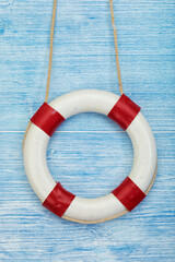 Lifebuoy hanging at blue painted wooden wall