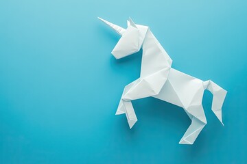 A handmade white, trendy geometrical polygonal paper origami unicorn on a blue background with empty space. Horizontal poster, postcard, or banner template