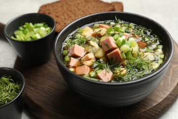 Delicious okroshka soup with kvass and ingredients on light table, closeup