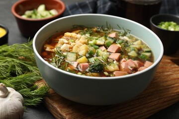 Delicious okroshka soup with kvass and ingredients on black table, closeup