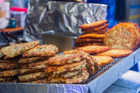 Bindae-tteok or mung bean pancakes cooking on an oil-covered griddle at Gwangjang Market in Seoul, Korea. Gwangjang Market, a famous local market, is a popular spot for traditional Korean street food.