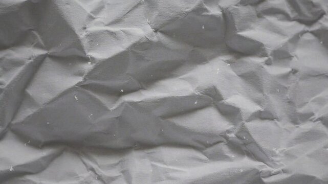 White crumpled wrinkled sheet of paper background texture. Stop motion animation. Seamless looping.