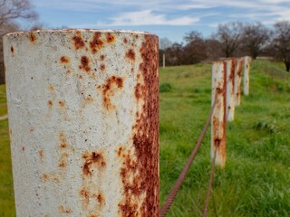 Rusty fence post with chain-link fence