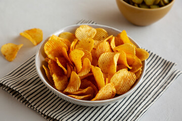 Crinkle Potato Chips and Green Pickle Chips in Bowls, side view.