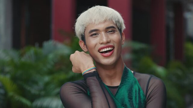 Charm Young Transgender Man Outdoors Posing and Smiling to the Camera. Portrait of the Attractive Guy with Makeup Outside, Queer People. Diversity LGBT Concept