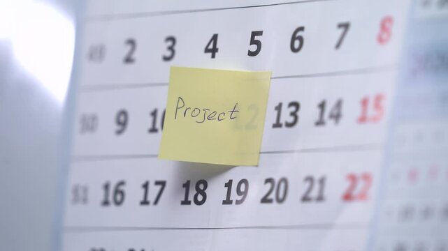 24 - Marking the date in the calendar with a red marker. The twenty-fourth day of the month, the hand encircles date 24 on the calendar. Vertical.