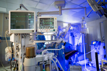 Surgical room medical gear. Advanced medical machines monitor patient vitals in an illuminated...