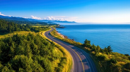 A breathtaking aerial view of a winding coastal road bordering a serene blue ocean, surrounded by lush greenery and mountains under a clear blue sky, perfect for travel and adventu