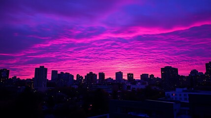 Fototapeta premium Vibrant Pink Sunset Over City Skyline Buildings