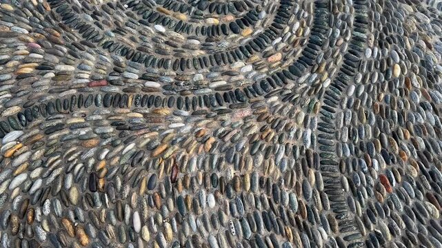 Footpath paved with pebbles and small cobblestones in sunny morning