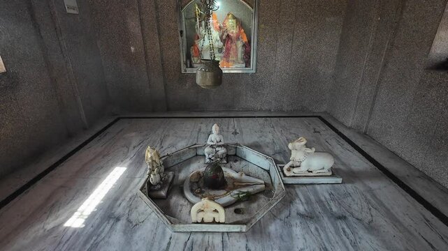 Spiritual Ambiance of a Devotional Hindu Temple Featuring a Shivling, Nandi Idols, and Intricate Religious Decor