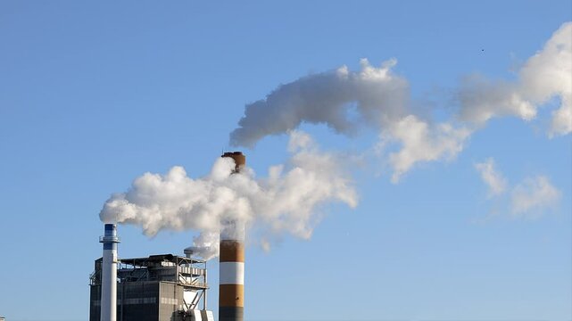 工場の煙突から煙が立ち上る,