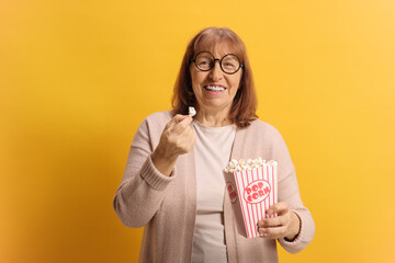 Elderly woman laughing against a yellow background