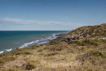 Ocean view from cliff rocky formations and waves hitting the coast. El Condor, Rio Negro, Argentina