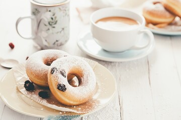 Vanilla baked donuts with dried cranberries dusted with powdered sugar