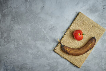 Ugly food. spoiled products lie on burlap on a gray concrete background
