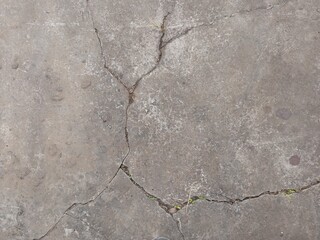 Cracked concrete surface with a linear pattern, illuminated by natural light