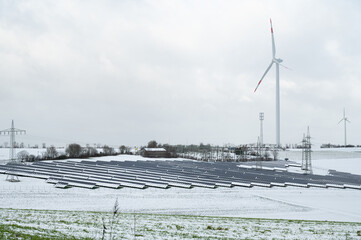 Windmill with solar panel in snow, dark doldrums or wind lull in winter, no renewable sustainable...