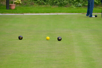 Crown green bowling on an outdoor green in rural Shropshire. The bowls are thrown towards the yellow jack and the nearest is awarded a point. A competitive  game played in teams or alone. 