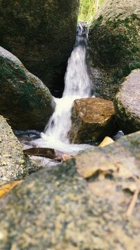 Close-up shot of a small stream stream pouring onto the rocks