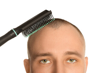Baldness problem. Man brushing his hair on white background, closeup