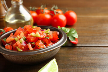 Delicious spicy salsa with ingredients on wooden table, closeup