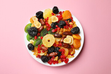Mix of different dried fruits on pink background, top view